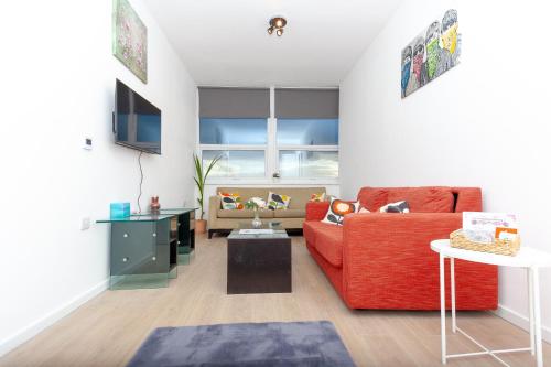 a living room with a red couch and a table at One Bedroom apartment Serviced apartment Smethwick flat 319 in Birmingham