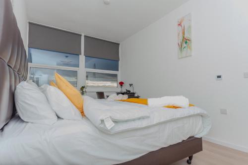 a large white bed with yellow and white pillows at One Bedroom apartment Serviced apartment Smethwick flat 319 in Birmingham
