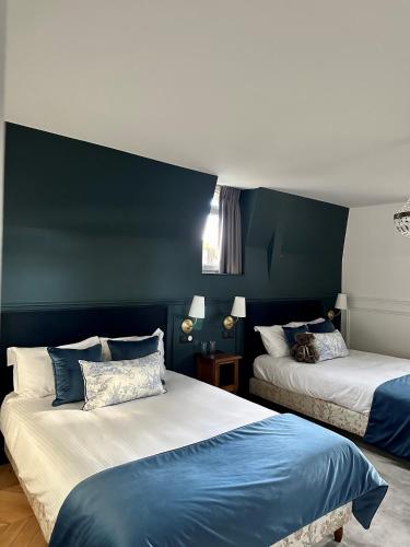 two beds in a room with blue and white walls at Château De La Bûcherie in Saint-Cyr-en-Arthies