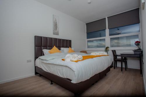 a bedroom with a large bed with towels on it at One Bedroom apartment Serviced apartment Smethwick flat 319 in Birmingham