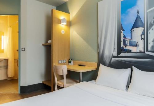 a bedroom with a bed and a desk and a table at B&B HOTEL Nancy Laxou Zenith in Nancy