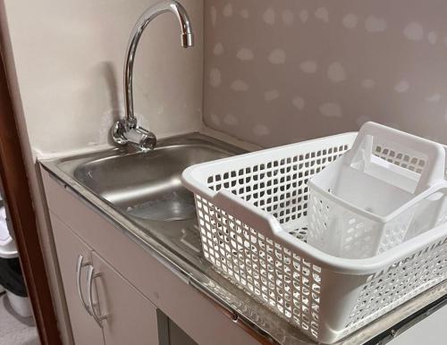 a kitchen sink with a white basket on the counter at Hostel Pepe Lima in Lima