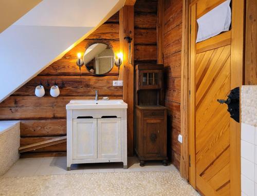 uma casa de banho com um lavatório e uma casa de banho com paredes de madeira em Siedlisko Chatka Zagajdzie 