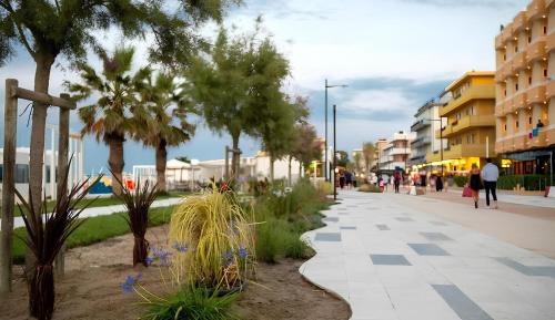 a city street with palm trees and buildings at Appartamento Torre Pedrera Rimini in Rimini