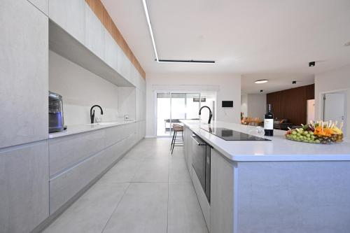 a large kitchen with white counters and a counter top at הבית בלב כנען - וילה מהממת עם בריכה פרטית מחוממת בצפת in Safed