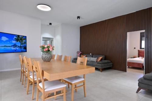 a dining room with a wooden table and chairs at הבית בלב כנען - וילה מהממת עם בריכה פרטית מחוממת בצפת in Safed