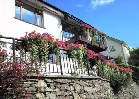 a building with flowers on a stone wall at Lingwood Lodge in Bowness-on-Windermere