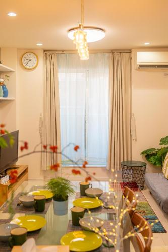 a living room with a glass table with yellow plates at sora西九条 in Osaka