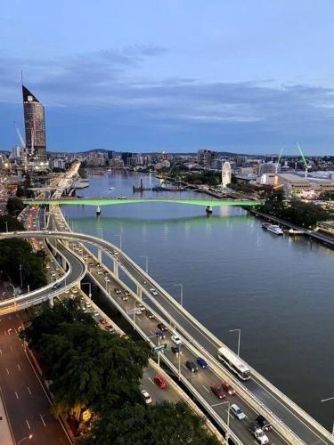 a city with a bridge over a river with traffic at Spectacular River View Apartment in Brisbane