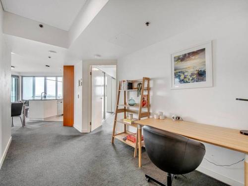 a living room with a desk and a kitchen at Spectacular River View Apartment in Brisbane