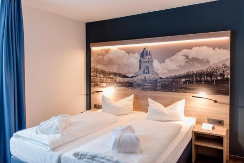 ライプツィヒにあるAtlanta Hotel Leipzigの壁に絵が描かれた部屋のベッド2台