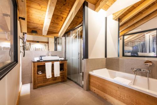a bathroom with a large tub and a shower at Chalet Carte Blanche Cullinan in Val Thorens