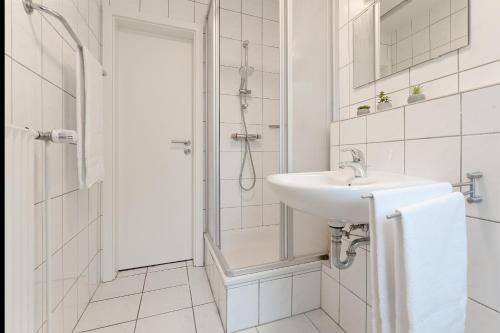 y baño blanco con lavabo y ducha. en Haus "Kehrwieder" Kap Arkona, en Grömitz