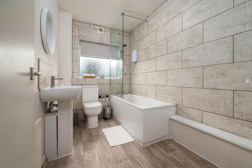 a bathroom with a sink and a toilet and a bath tub at Watling Apartments Tamworth in Tamworth