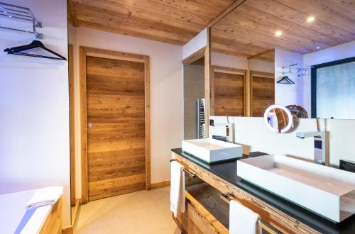 a bathroom with two sinks and a wooden door at Chalet Carte Blanche Orlov in Val Thorens