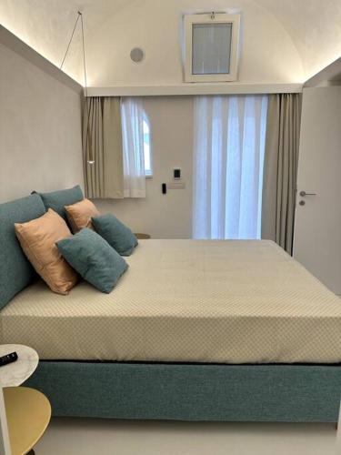 une chambre avec un grand lit avec des oreillers dessus dans l'établissement Piazzetta Suite, Capri, à Capri