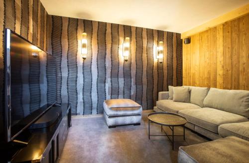 a living room with a couch and a tv at Chalet Cullinan by Les Etincelles in Val Thorens