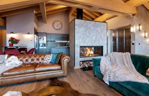 un salon avec un canapé et une cheminée dans l'établissement Chalet Carte Blanche Orlov, à Val Thorens
