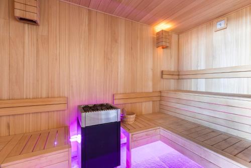 a sauna with a stove and purple lights in it at Chalet Cullinan by Les Etincelles in Val Thorens