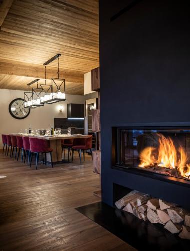 a living room with a fireplace and a dining room at Chalet Cullinan by Les Etincelles in Val Thorens
