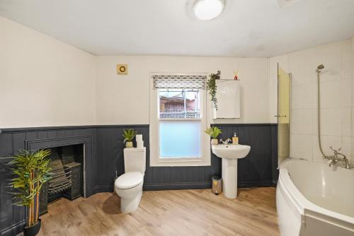 a bathroom with a toilet and a sink and a tub at The Bristol Harbourside Apartments - Sleeps 16 in Bristol