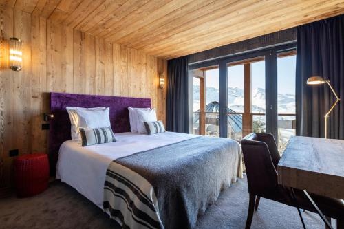 a bedroom with a bed with a purple head board at Chalet Carte Blanche Cullinan in Val Thorens