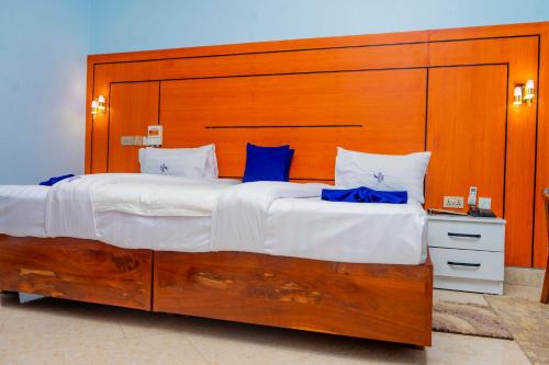 een groot bed met een groot houten hoofdeinde bij La Stanar Hotel in Dodoma