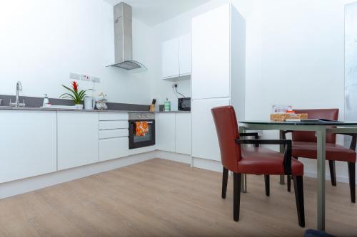 een keuken met een tafel en stoelen en een open haard bij One Bedroom apartment Serviced apartment Smethwick flat 313 in Birmingham