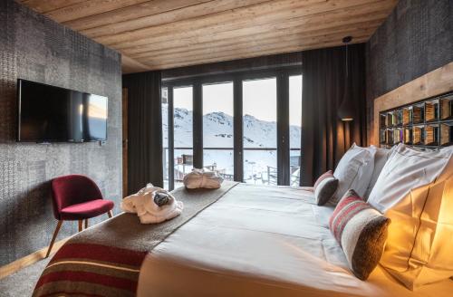 a bedroom with a large bed with a television on a wall at Chalet Carte Blanche Orlov in Val Thorens