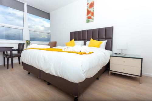 een slaapkamer met een groot bed met gele kussens bij One Bedroom apartment Serviced apartment Smethwick flat 313 in Birmingham