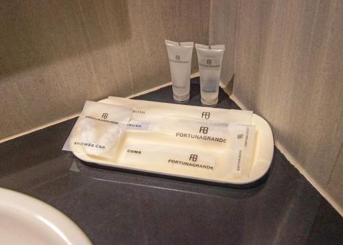 dos pilas de papel higiénico en una encimera en un baño en Hotel FortunaGrande Seturan Yogyakarta, en Yogyakarta