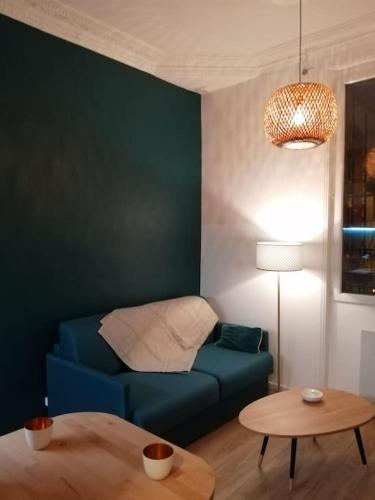 un salon avec un canapé bleu et une table dans l'établissement A 300 mètres de Paris 13, superbe deux pièces neuf, à Ivry-sur-Seine