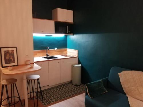 uma pequena cozinha com um lavatório e uma mesa em A 300 mètres de Paris 13, superbe deux pièces neuf em Ivry-sur-Seine