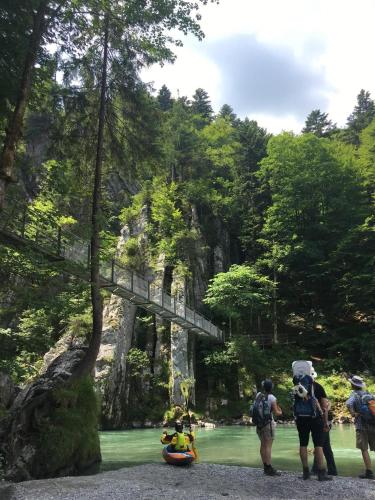 a group of people standing next to a river with a bridge at Ferienwohnung Zum Lenei in Staudach-Egerndach