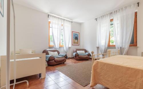 1 dormitorio con 1 cama, sillas y ventanas en Italian Experience - Sunrise Hill Holiday Home, en Urbisaglia