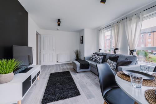 a living room with a couch and a tv at ComfySleep Apartments in Glasgow