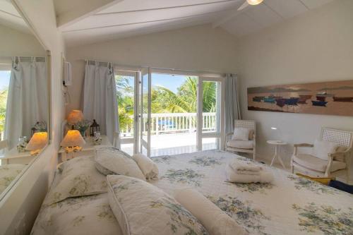 Un dormitorio con una cama grande y un balcón. en Harmoniosa Mansão a poucos passos da Praia, en Búzios