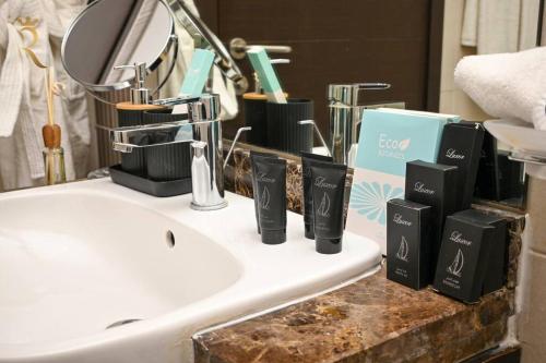 een wastafel in de badkamer met zeepdispensers op een aanrecht bij Luminous 1BR Apartment Al reem in Abu Dhabi
