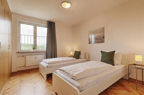 基青根的住宿－Apartmenthaus Kitzingen - großzügige Wohnungen für je 4-8 Personen mit Balkon，一间卧室设有两张床和窗户。