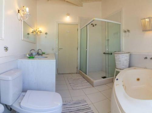 Un baño con inodoro, ducha y lavabo. en Harmoniosa Mansão a poucos passos da Praia, en Búzios