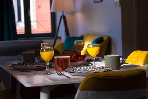 a table with glasses of orange juice and food on it at Le 10-GregIMMO-Appart'Hôtel in Belfort