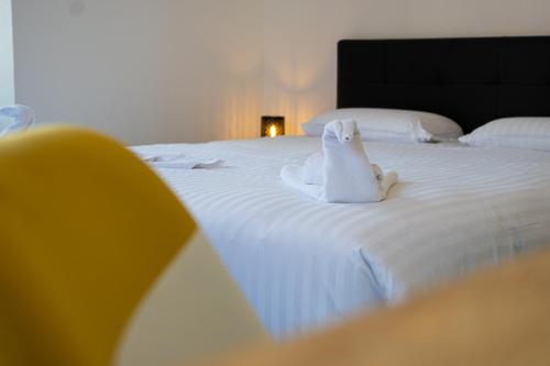 a white stuffed cat sitting on top of a bed at Le 10-GregIMMO-Appart'Hôtel in Belfort