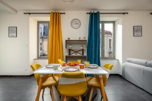 a dining room with a table and yellow chairs at Le 10-GregIMMO-Appart'Hôtel in Belfort