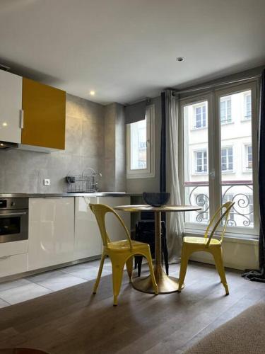 une cuisine avec des chaises jaunes, une table et une fenêtre dans l'établissement 4 personnes - St Lazar sur cour, à Paris