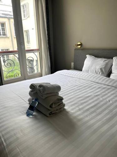 - une chambre avec un lit, des serviettes et une fenêtre dans l'établissement 4 personnes - St Lazar sur cour, à Paris