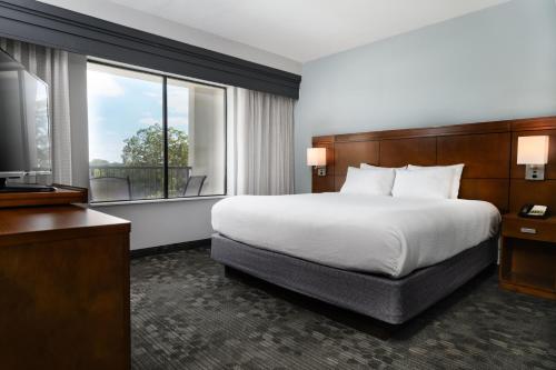 a hotel room with a bed and a window at Courtyard by Marriott New Braunfels River Village in New Braunfels