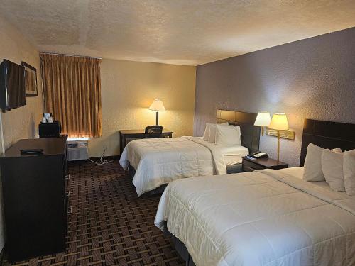 um quarto de hotel com duas camas e duas lâmpadas em Rodeway Inn Fort Myers Central em Fort Myers