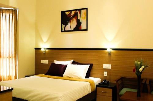 a hotel room with a bed at Kohinoor Hotels in Erode