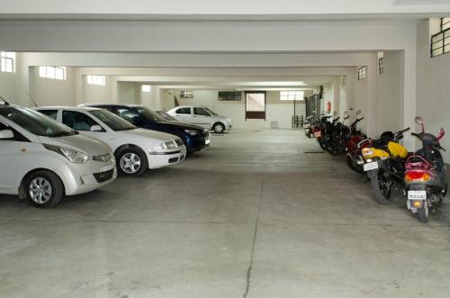 a garage with cars and motorcycles parked in it at Kohinoor Hotels in Erode