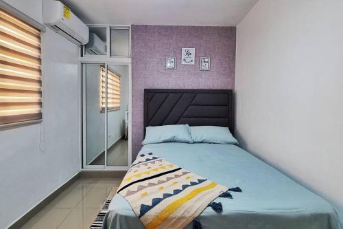 a bedroom with a bed with a purple wall at Apartamento acogedor Ashmi in Santiago de los Caballeros